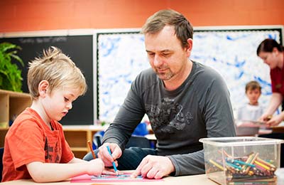 YMCA child care teacher with school age student