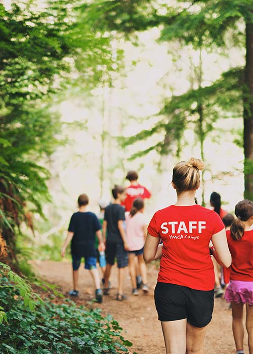 YMCA Camp Presqu'ile staff leading children through trail