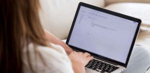 Person typing cover letter on laptop