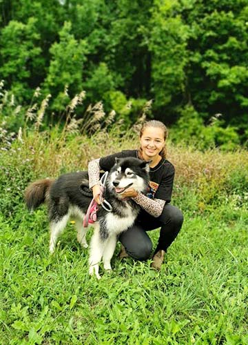 Young girl with arms around a Husky dog