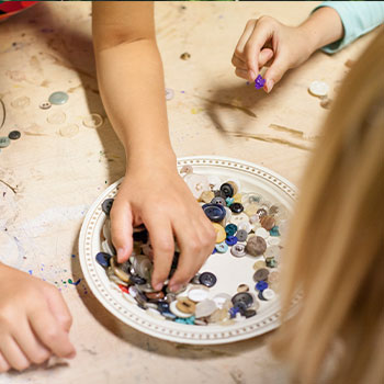 Hands picking up buttons and beads