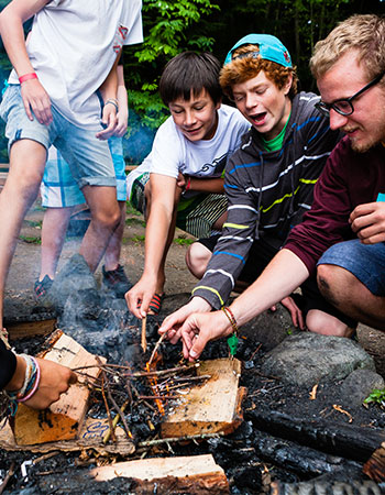 Young boys having fun around a camp fire