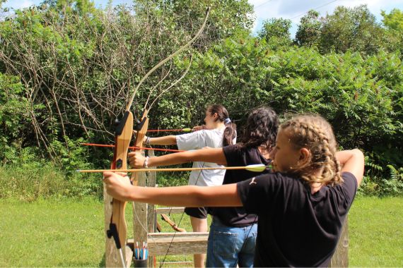 young girls learning archery