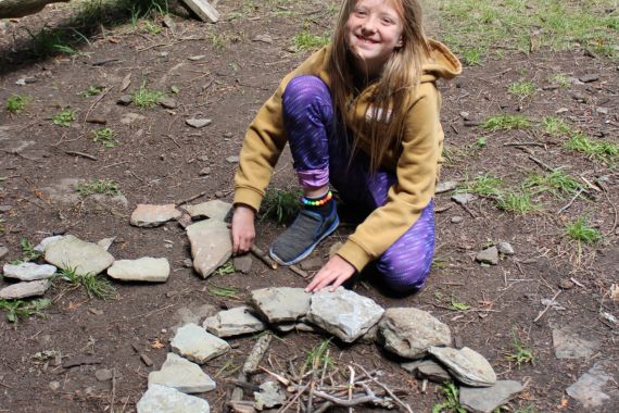 Girl building camp fire at Camp Presqu'ile