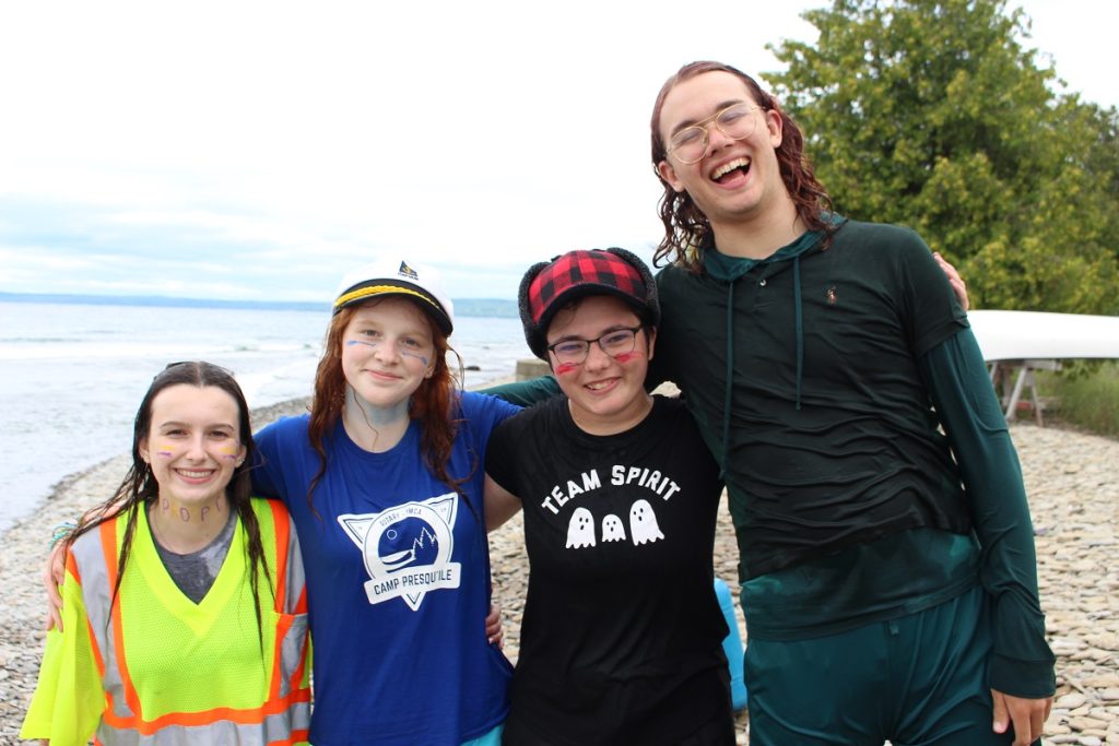 Group of youth laughing while standing on beach