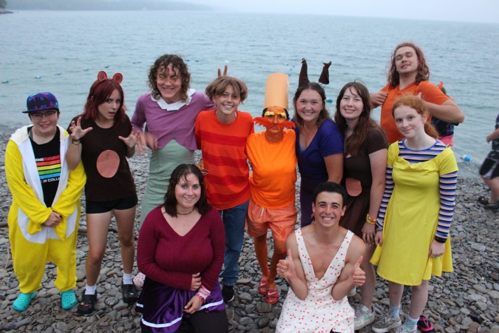 Youth dressed up in silly costumes standing on beach